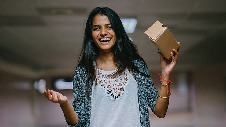 Frau mit Lächeln hält 360°-Küchenvisualisierung in der Hand; CARAT view Logo mit Slogan 'Küchen in 360° erleben'.